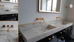 Comptoir de salle de bain en marbre blanc avec lavabos intégrés et armoires noires.